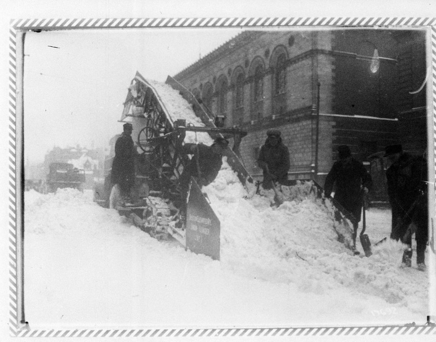 Men shoveling snow on to snow conveyor in Copley Square, Boston, Mass ...